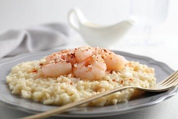 Delicious risotto with shrimps and cheese on table, closeup