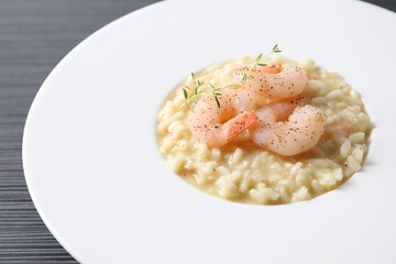 Delicious risotto with shrimps and cheese on black table