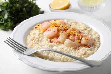 Delicious risotto with shrimps and cheese on white table, closeup