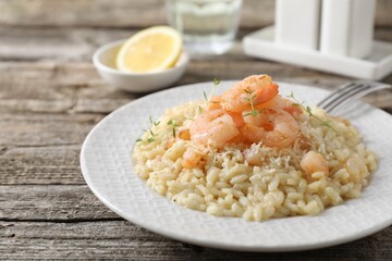 Delicious risotto with shrimps and cheese on wooden table, closeup