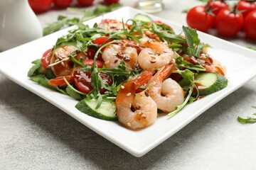 Delicious shrimp salad with vegetables on grey textured table, closeup