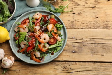 Delicious shrimp salad with ingredients on wooden table, flat lay. Space for text