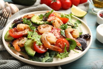 Delicious shrimp salad and ingredients on light blue wooden table, closeup