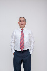 Confident asian businessman wearing a red striped tie, smiling at the camera in a studio setting.