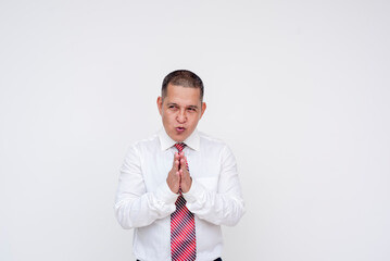 A local middle aged asian politician rubbing his hands, scheming to put his devious plans into effect. Set against a white background.