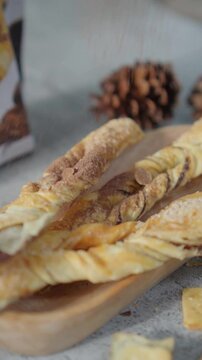 Sprinkle cocoa powder on Crispy Pastry Sticks.
