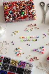 Making friendship bracelets with letter beads. Jewelry making supplies on the table. Selective focus.