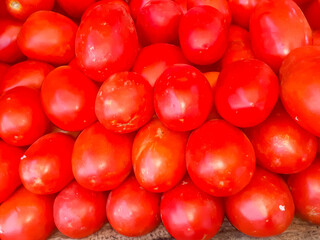 Red tomatoes background, ripe tomatoes pile arranged at market for sale. 