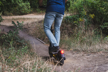 A man rides down a hill on an electric scooter over rough terrain