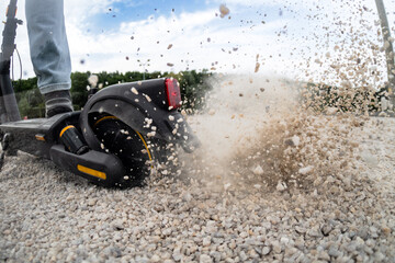 Starting a scooter on a gravel road with slipping and flying stones