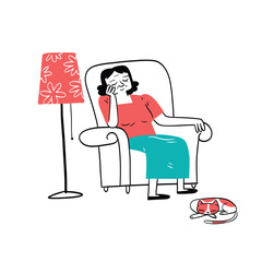 A woman naps in an armchair beside a sleeping cat