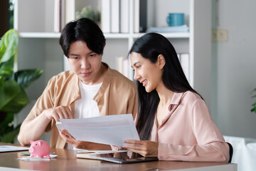 Young Couple Managing financial and Saving Money with Piggy Bank at Home, Discussing Financial Plans and Banking