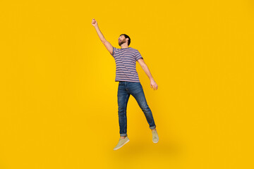 Full length body photo of young adult bearded man jumping trying to catch miniature bird isolated...