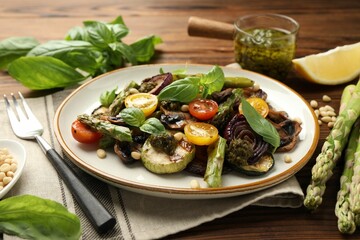 Delicious salad with grilled vegetables and fork on wooden table, closeup