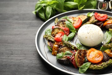 Tasty salad with grilled vegetables and mozzarella cheese on black table, closeup. Space for text