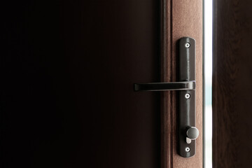 The brown plastic door to the street is ajar
