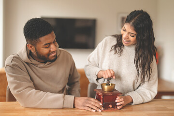 Couple Joyfully Grinding Coffee Together at Home in a Warm and Inviting Kitchen Setting