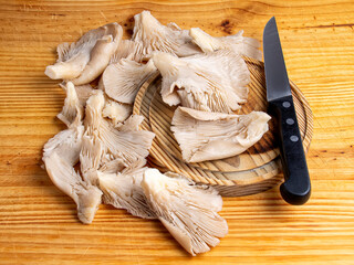 Setas y cuchillo sobre tabla de madera de cocina