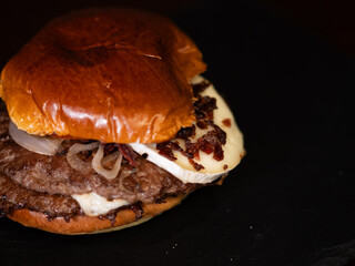 Cheese burger with bacon and egg on black background	
