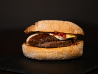 Cheese burger with bacon on black background