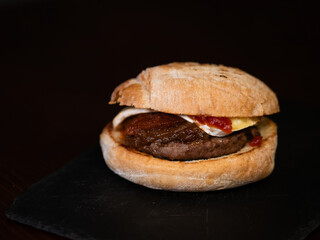 Cheese burger with bacon on black background