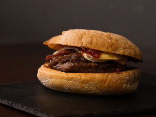 Cheese burger with bacon on black background