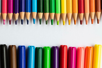 Colored pencils, pencils, ruler, notebook, pencil sharpener and eraser. Material for back to school. Above the school table.
