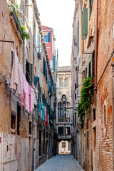 A stunningly picturesque alley in the heart of Venice, showcasing laundry hanging among beautiful historic buildings
