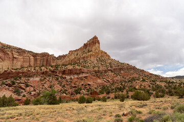 Fototapeta premium A cloudy and sunny view of red rocks at Capitol Reef National Park in Utah.