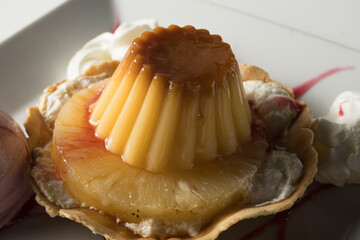 Postre Pijama con flan, pi&ntilde;a y helado de fresa sobre plato blanco