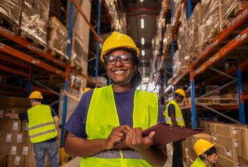 Smiling African Warehouse Worker Holding Clipboard in Aisle