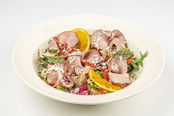 Delicious salad with slices of roast beef, salad mix, sun-dried tomatoes, grilled mushrooms dressed with cheese sauce