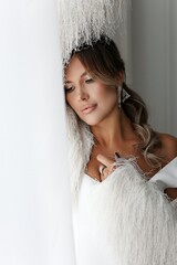 Professional studio portrait of a well-groomed brunette in white. Feminine, beautiful middle age.