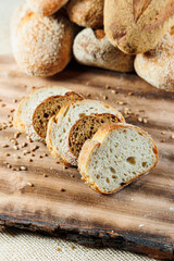 Fresh craft bread sliced on a wooden board on a dark concrete background. Homemade baking