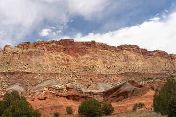A cloudy and sunny view of red rocks at Capitol Reef National Park in Utah.