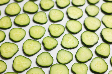 Slices of fresh cucumbers on white background