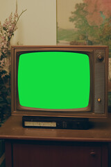 Retro TV with green screen in a vintage setting for creative media use.