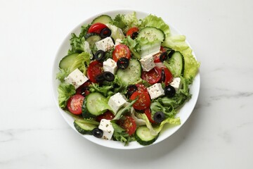 Delicious salad with feta cheese on white marble table, top view