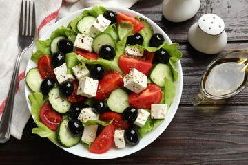 Delicious salad with feta cheese served on wooden table, flat lay