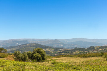Fototapeta premium Northern Portuguese landscape with green mountains and hills and a blue sky. In the Portuguese district of Braga near the town of Fafe.
