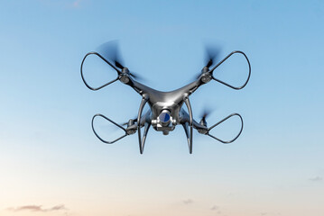 Modern drone with a camera flies in the sky.