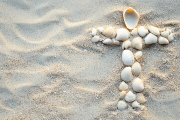 A Cross of Hope: Seashells Form a Sacred Symbol on a Sandy Beach