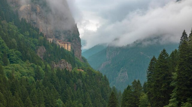 Sumela Monastery time lapse 4k video with motion of the clouds. Altindere Valley National Park view with Sumela Monastery at foggy weather. Visit Trabzon concept video.