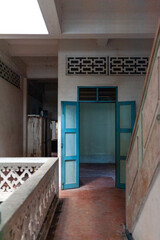 An inviting interior hallway featuring traditional architecture with vibrant blue doors and interesting textures.
