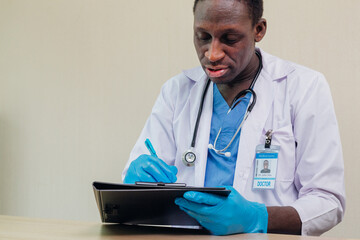 African American doctor writing prescription on a clipboard in a medical setting. medical...