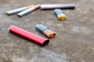 Personal vaporizer e-cigarette e-juice liquid plastic bottle placed on cement floor, soft and selective focus on liquid bottle.