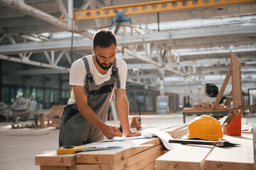 Fototapeta premium Bunch of paper documents and plans. Industrial worker in wooden warehouse