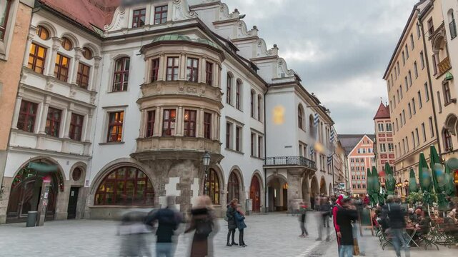 Cityscape with bier houses and restaurants outdoors on Platzl timelapse in Munich, Bayern, Germany. Walking area with tables and chairs. People relaxing in cafes