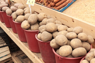 Buckets of ripe potatoes sold at a seasonal open market with other vegetables in Vilnius, Lithuania, at a low price