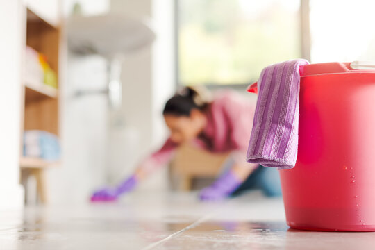 Woman kneeling on the floor and cleaning with a cloth
